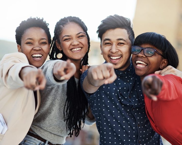 Join us today. Portrait of a group of happy students pointing toward the camera.